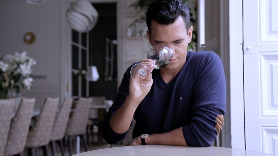 Cruz nosing a glass of white wine