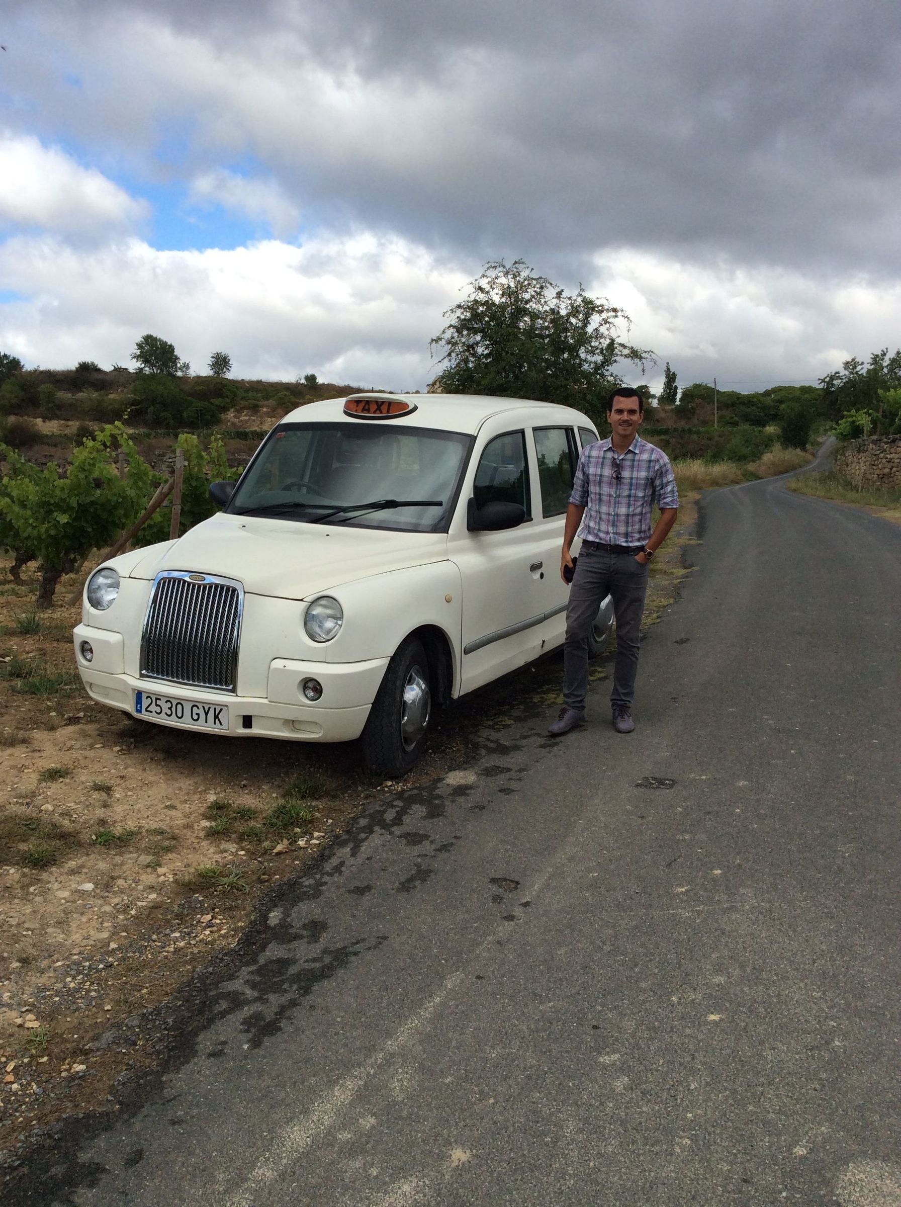 Cruz beside a London taxi among vineyards